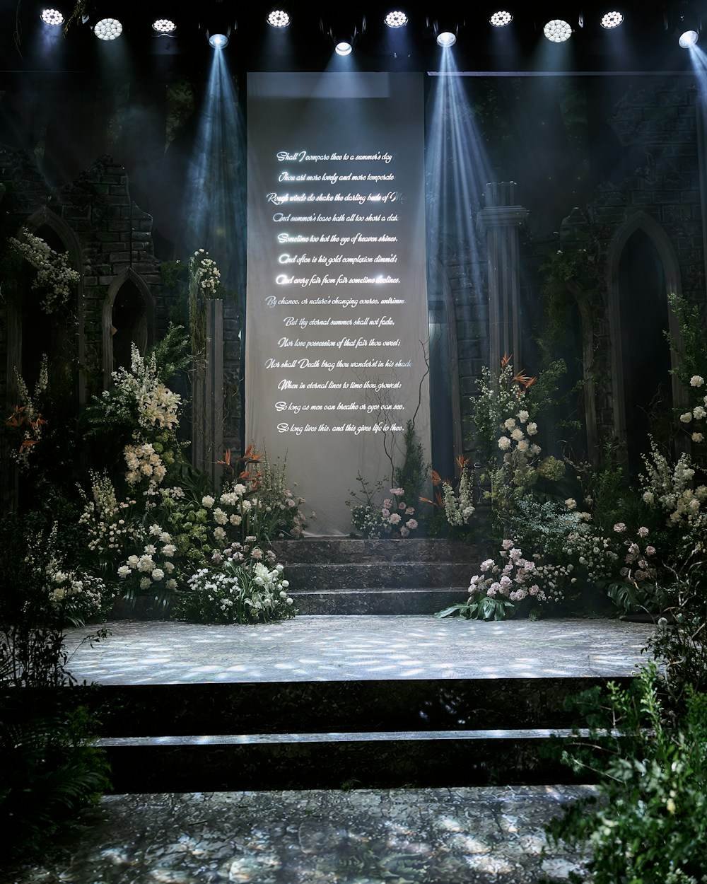 A lit stage and floral backdrop built for a wedding