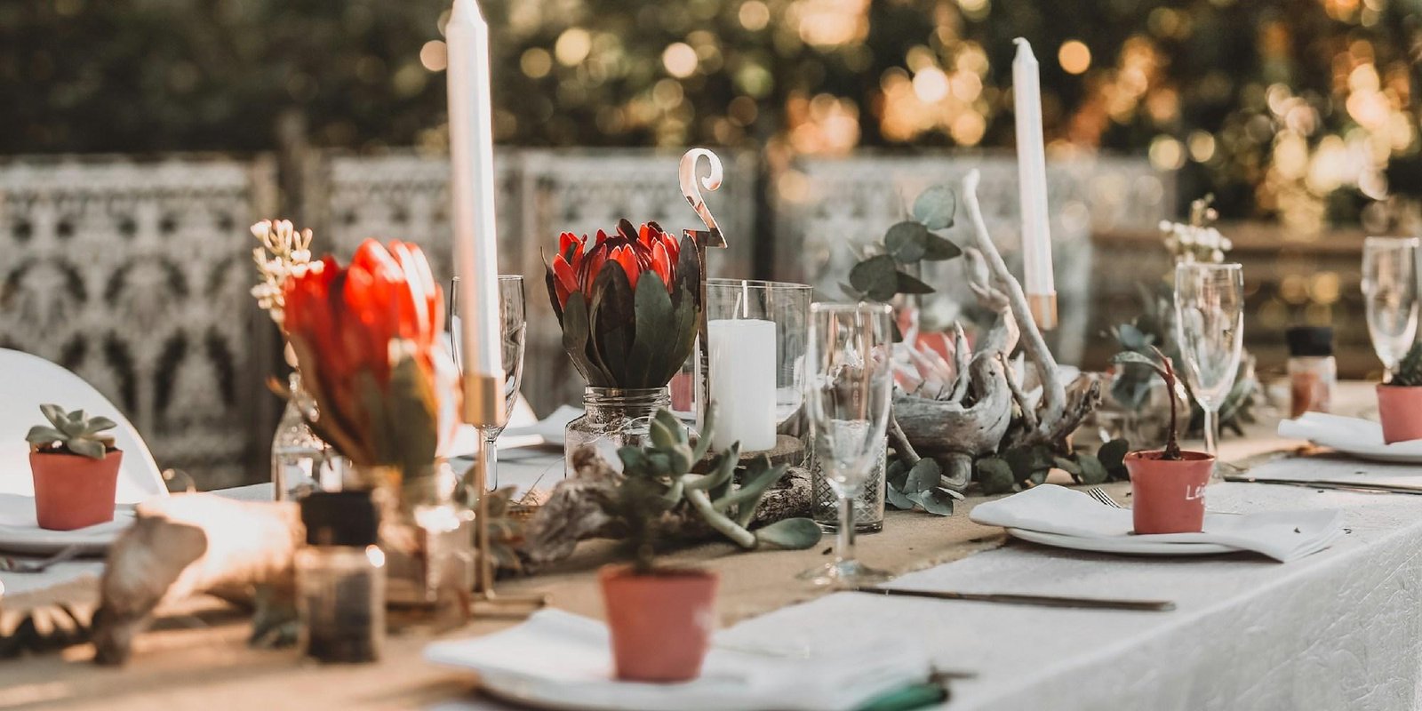 A long table dressed and lit for a reception